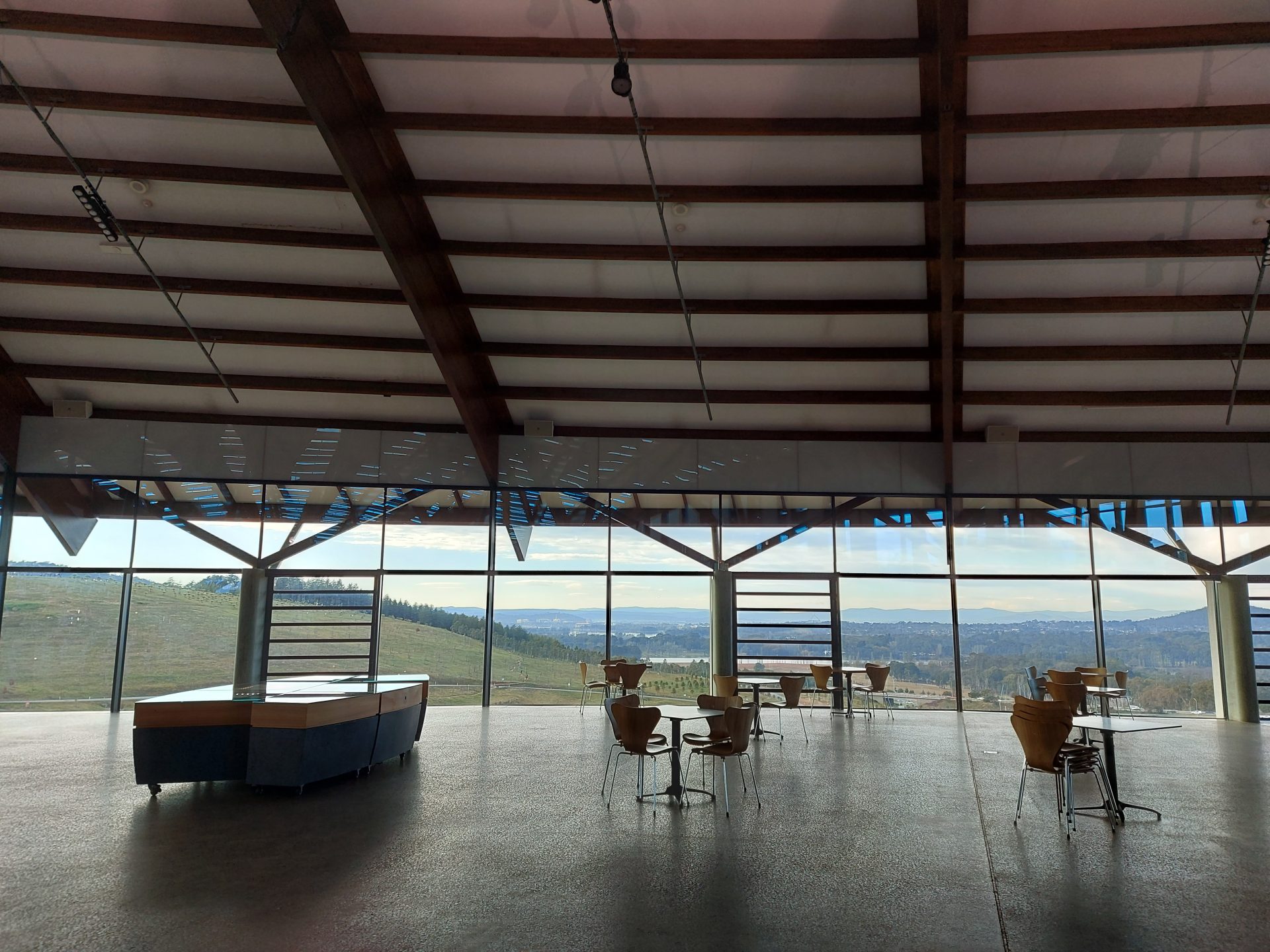 Empty visitor centre with sparse arrangement of tables and chairs 