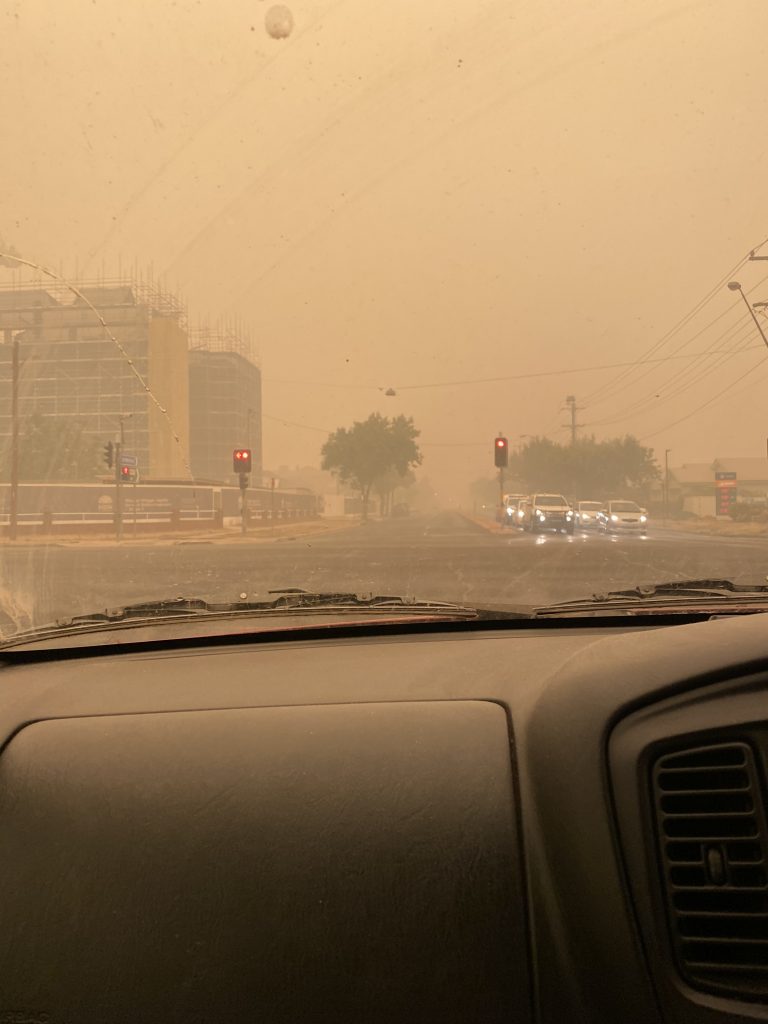 A photograph taken from inside a car looking at bushfire smoke covering the city of Wagga Wagga