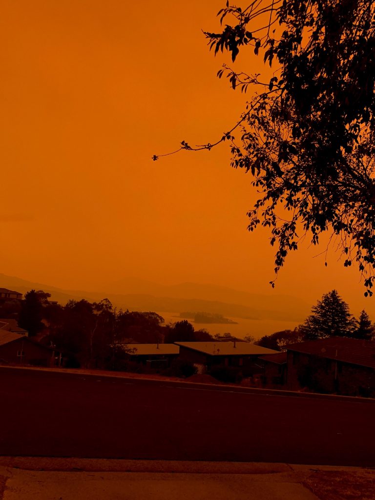 A view over suburban properties in the town of Jindabyene. The sky is orange because of nearby bush fires.