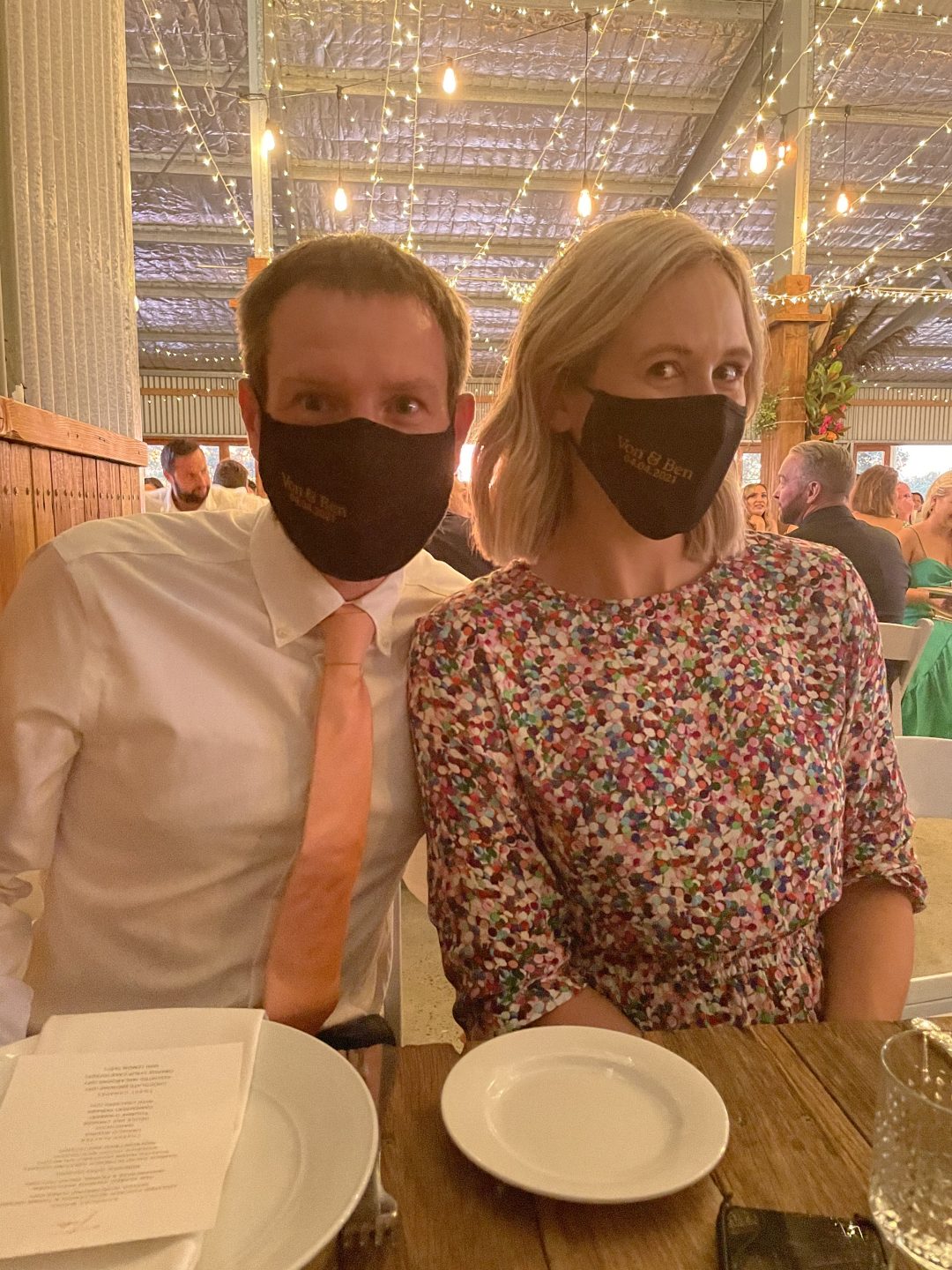 a couple at a wedding with black face masks on.
