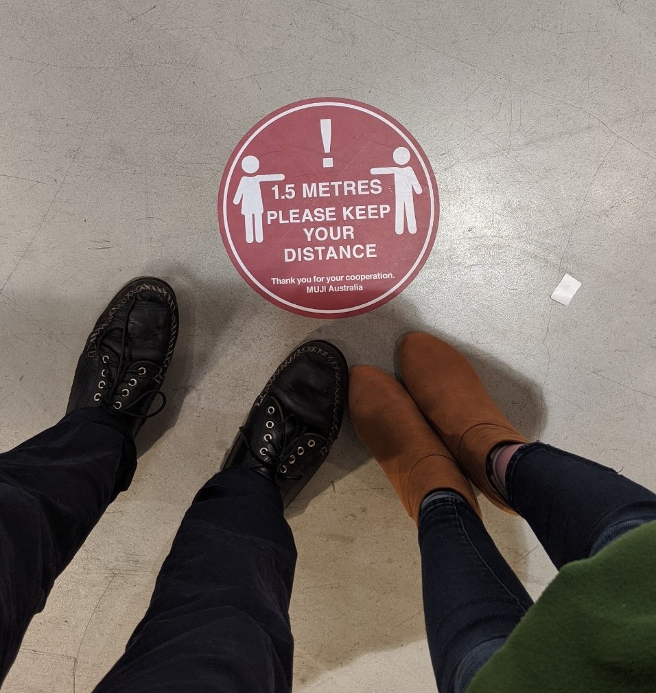 a red sticker on the ground telling people to keep 1.5 metres apart.