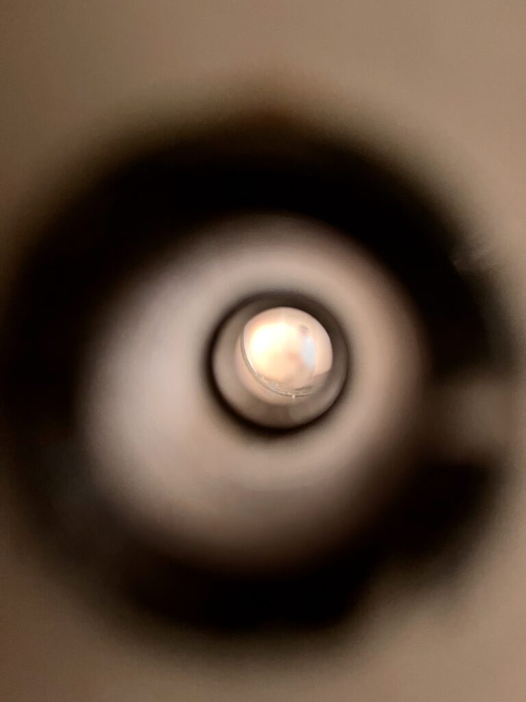 a photo looking through a peephole of a hotel room door. 