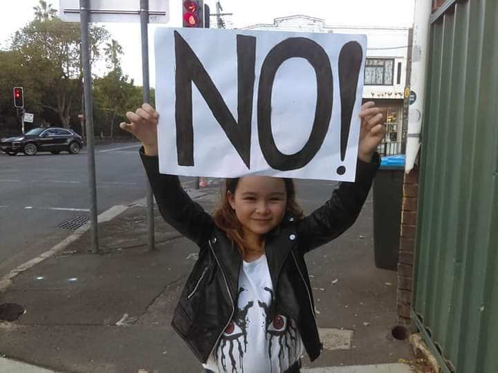 Girl holding a 'No!' sign on the street