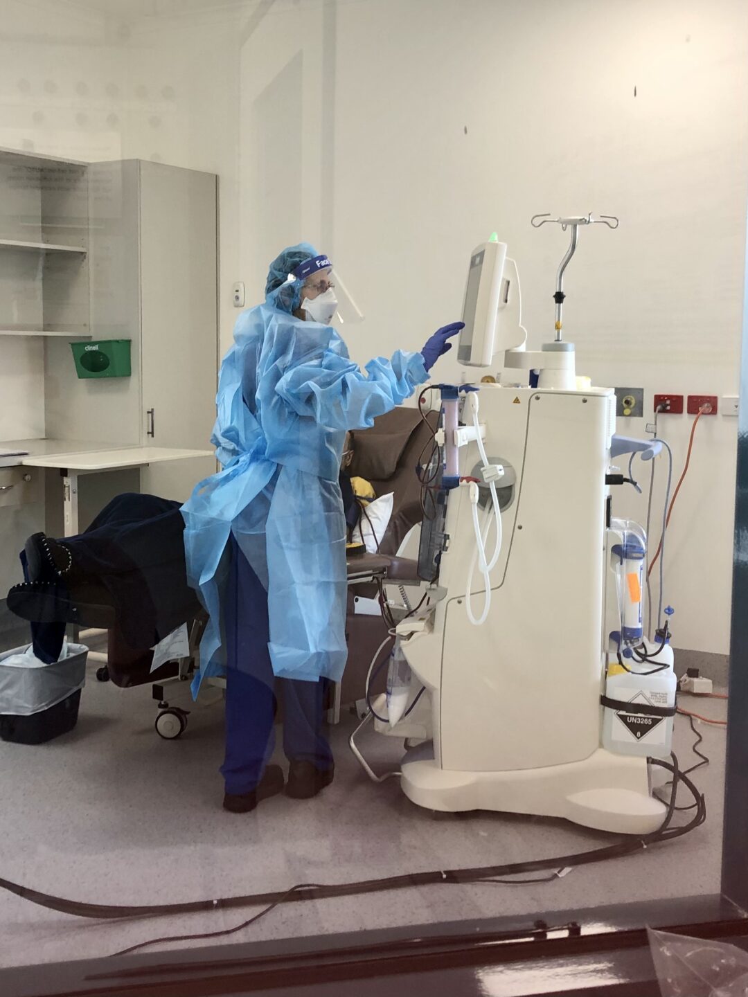 A photo of a nurse using a dialysis machine.