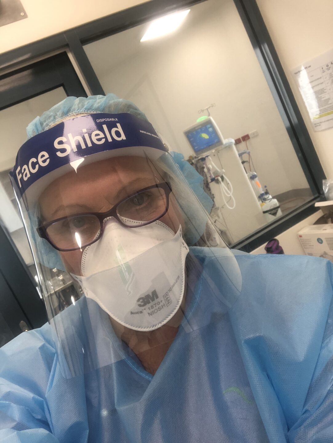 A photo of a nurse in full PPE including face shield.